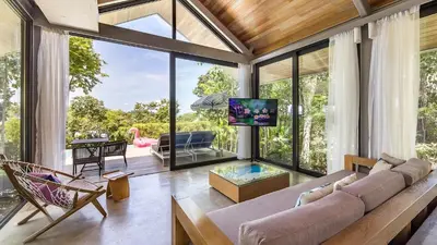 a living room with a couch and a tv at Villa Escape Burasari in Phuket Town