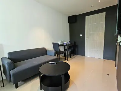 a living room with a couch and a table at Aya Residence Garden View in Ban Ket Ho