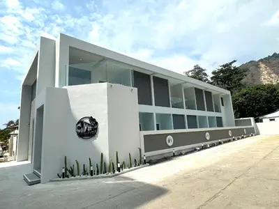 a white building with a sign on the side of it at Kata Place Villa in Kata Beach