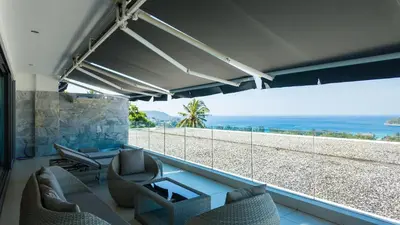 a living room with a view of the beach at The Kata View Phuket apartment in Kata Beach
