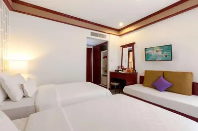 a hotel room with two beds and a couch at THE TOP PATONG RESORT. in Patong Beach
