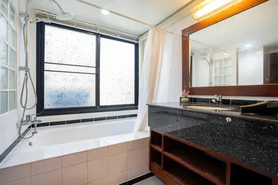 a bathroom with a tub and a sink and a mirror at Beachside Apt Short Walk to Nai Harn Beach 2-3 BR in Nai Harn Beach