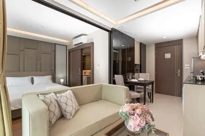 a hotel room with a couch and a bedroom at The Panora apartments by NLA in Surin Beach