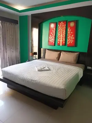 a bedroom with a large bed with red and green walls at New Lavender Hotel Patong in Patong Beach