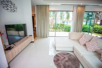 a living room with a white couch and a flat screen tv at Phuket Boutique Pool Villa-81 in Rawai Beach