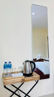 a mirror on a wall with a tea kettle on a shelf at Jasmin Guest House in Patong Beach