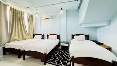 two beds in a room with blue walls at Jasmin Guest House in Patong Beach