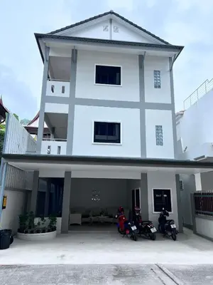 two motorcycles parked in front of a white building at M&N Guesthouse Kata in Kata Beach