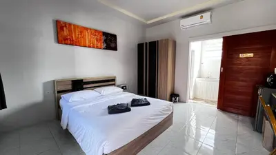 a bedroom with a bed with shoes on it at M&N Guesthouse Kata in Kata Beach