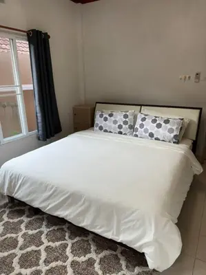 a bedroom with a white bed with pillows and a window at Kathu Home with Mountain View in Kathu