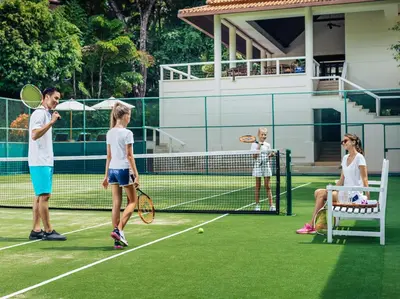 a group of people playing tennis on a tennis court at Katamanda 1Bedrooms Apartment near Kata Beach in Kata Beach