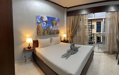 a bedroom with a large bed and two lamps at S a f e Residence Patong in Patong Beach