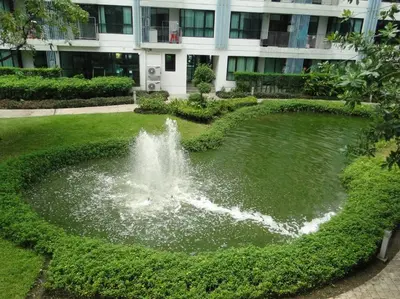 a fountain in a park in front of a building at Apartment near Central phuket in Phuket Town