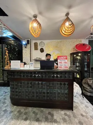 a man standing behind a counter with a laptop at Blueskyhouse Patong in Patong Beach