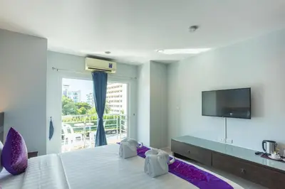 a hotel room with a bed and a tv at The Great @Patong Hotel in Patong Beach