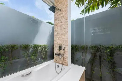 a bathroom with a tub and a glass window at Villa Maya 2BR private pool villa Nai Harn beach in Rawai Beach