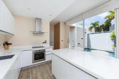 a kitchen with white counters and a large window at Villa Maya 2BR private pool villa Nai Harn beach in Rawai Beach