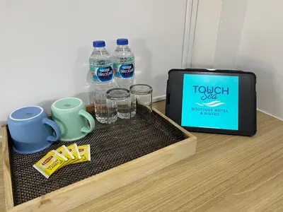 a tray with water bottles and glasses next to a box at Touch Sea Boutique Hotel&Bistro in Karon Beach