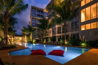 a swimming pool with red pillows in front of a building at Diamond Phuket Bang Tao in Bang Tao Beach