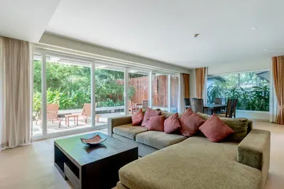 a living room with a couch and a table at Poppy Beachfront Residence in Rawai Beach