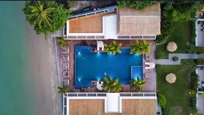 an overhead view of a swimming pool next to a beach at Poppy Beachfront Residence in Rawai Beach