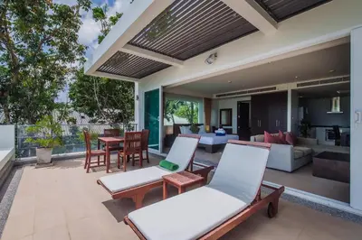 an outdoor patio with chairs and a living room at Daisy 2 Bedroom Amazing Seaview in Rawai Beach