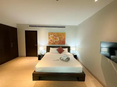 a bedroom with a large bed and a tv at Olive 1 Bedroom Beachfront in Rawai Beach