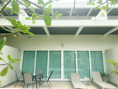 a patio with a table and chairs in a building at Olive 1 Bedroom Beachfront in Rawai Beach