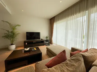a living room with a couch and a tv at Olive 1 Bedroom Beachfront in Rawai Beach
