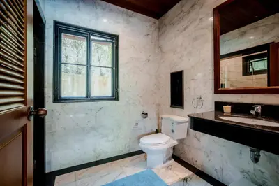 a bathroom with a toilet and a sink and a window at Solas Pool Villa Grand Villa With Private Pool in Rawai Beach