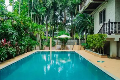 a swimming pool in front of a house with trees at Orchid Pool Villa Lavish Villa In Perfect Location in Rawai Beach