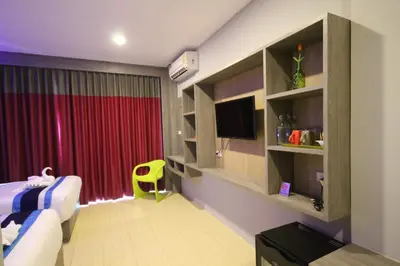 a bedroom with a bed and a tv and a red curtain at KRABI Residence in Ban Khlong Haeng