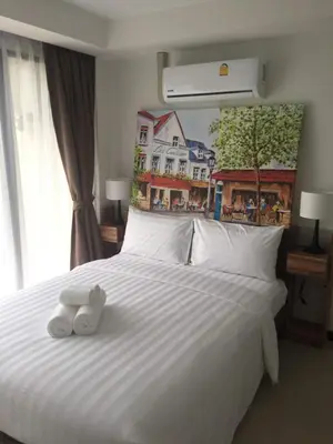 two stuffed animals sitting on top of a white bed at Mai Khao Beach Apartments in Mai Khao Beach