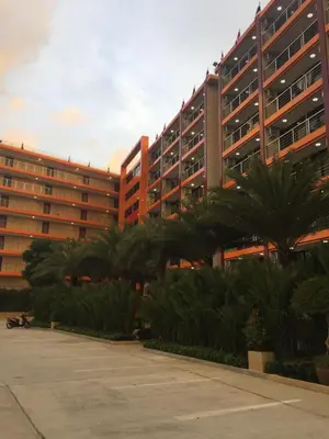 a large building with palm trees in front of it at Mai Khao Beach Apartments in Mai Khao Beach