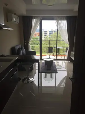 a kitchen with a table and a view of a patio at Mai Khao Beach Apartments in Mai Khao Beach