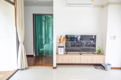 a living room with a couch and a television at Phuket Boutique Pool Villa-80 in Rawai Beach