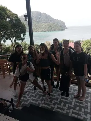 a group of people posing for a picture in front of the ocean at The view Hostel in Phi Phi Don
