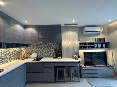 a kitchen with black cabinets and a white counter top at Luxury one apartment for rent Kamala in Kathu