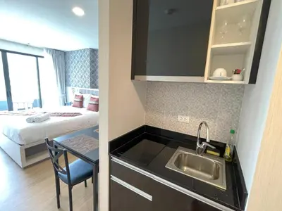 a kitchen with a sink and a room with a bed at Cozy studio Splendid Condo by Lofty in Kata Beach