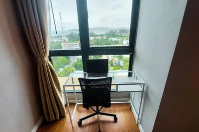 a desk with a laptop on it in front of a window at Seaview Condo In 5 Star Resort MG1 in Phuket Town