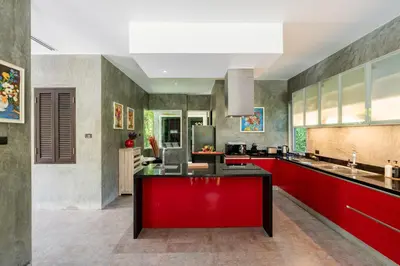 a kitchen with red cabinets and a red island at VILLA FLORA - North Phuket, Naiyang Beach area in Nai Yang Beach