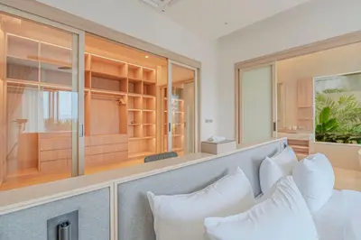 a living room with white furniture and windows at The Salin Seaview Villas in Kata Beach