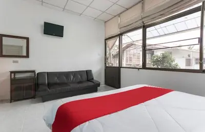 a living room with a bed and a couch at THE NAIYANGHOUSE in Nai Yang Beach