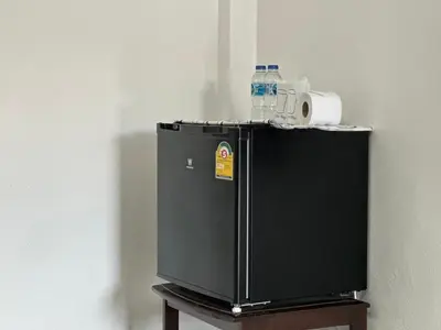 a small black refrigerator with a bottle of water on top at THE NAIYANGHOUSE in Nai Yang Beach
