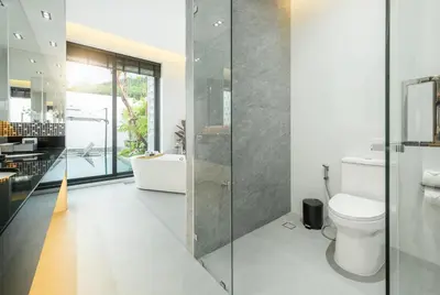 a bathroom with a toilet and a glass shower at New 3BR Private Pool Villa with 5 Stars Resort Service in Rawai Beach