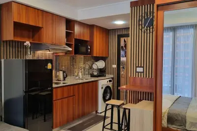 a kitchen with wooden cabinets and a bed in a room at CB408 Apartament Beach condo 777 in Phuket Town