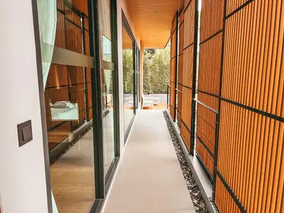 an internal corridor of a house with glass doors and a hallway at Le Villa Residence in Phuket Town