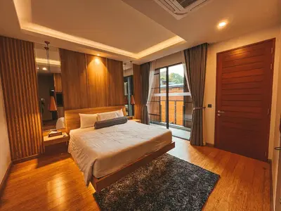 a bedroom with a bed and a large window at Le Villa Residence in Phuket Town