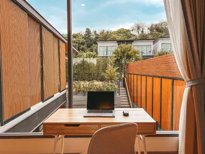 a laptop computer sitting on a desk on a balcony at Le Villa Residence in Phuket Town