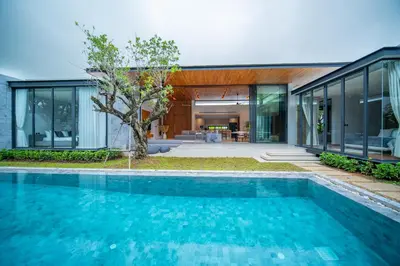 a swimming pool in front of a house at Botanica Foresta 4BR Luxury Villa with Pool by NLA in Bang Tao Beach